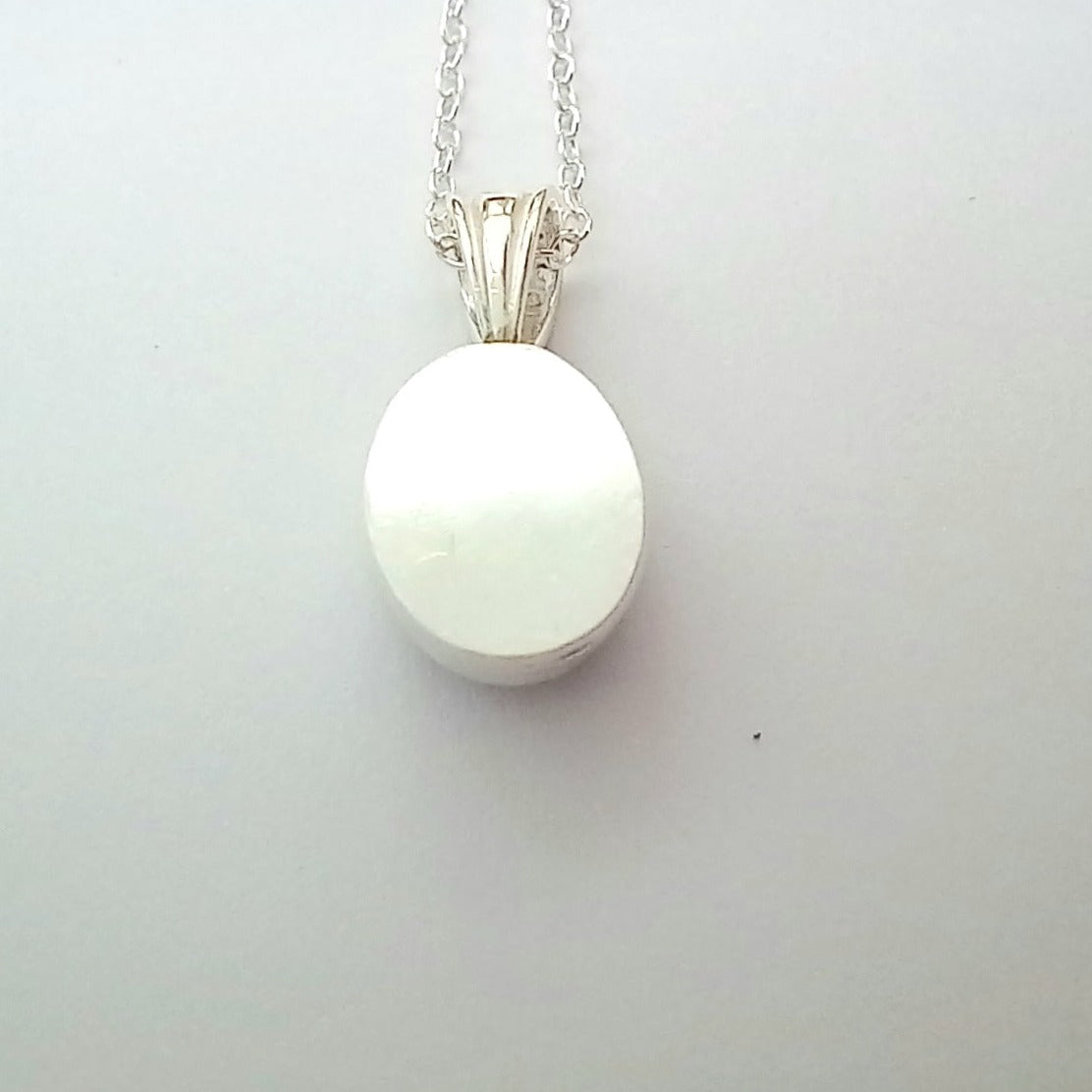Back of oval amethyst pendant with bail and chain.